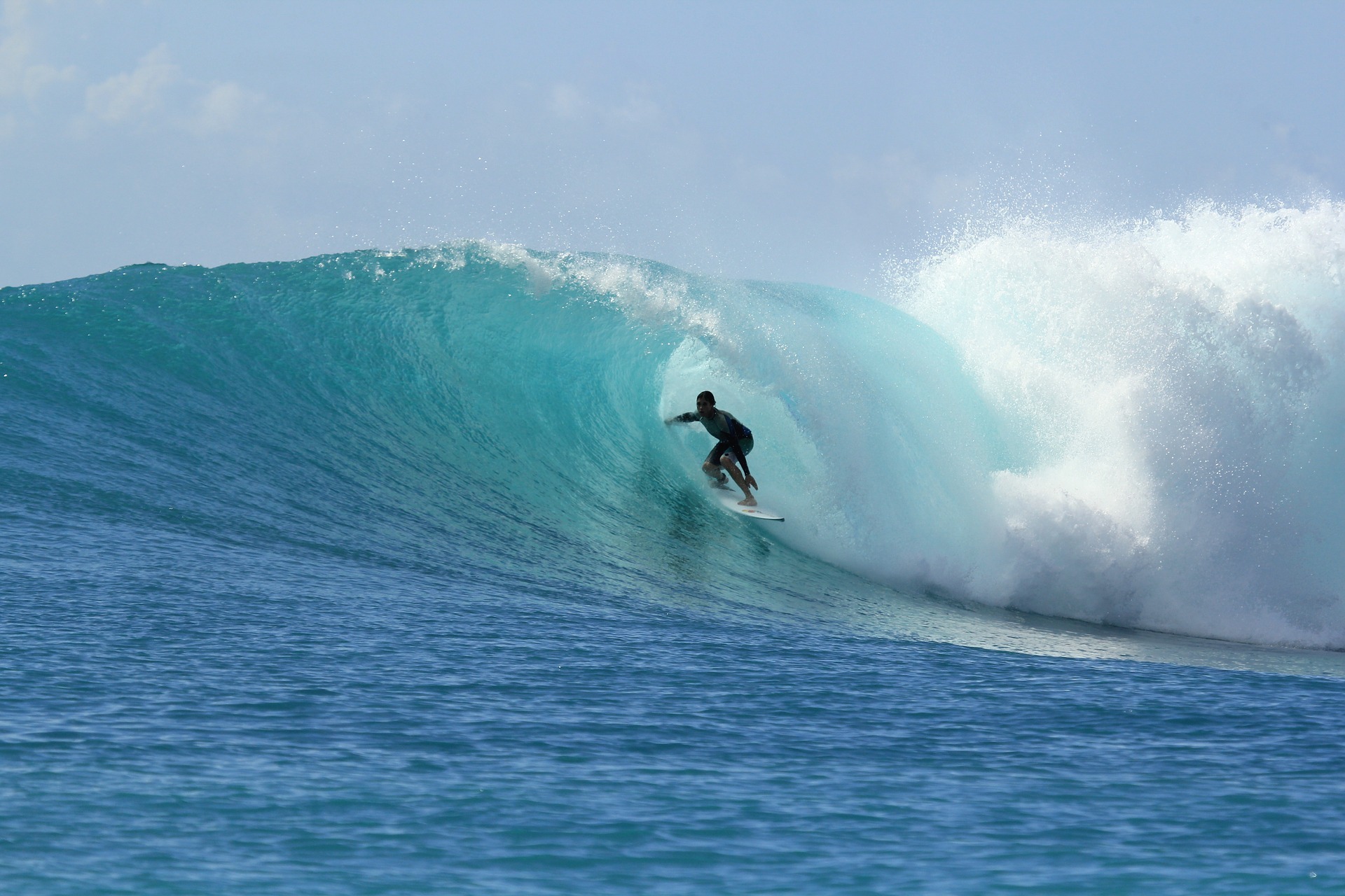 surfer cabalgando la ola con seguro multiaventura