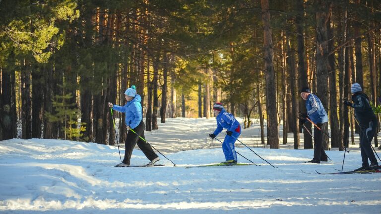 Familia de tres personas esquiando en un terreno plano